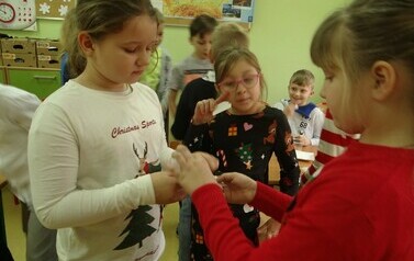 Uczennice klasy drugiej dzielące się opłatkiem