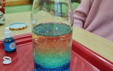 Butelka z kolorowymi substancjami o r&oacute;żnej gęstości