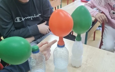 Uczniowie wykonują doświadczenia samopompujące się balony