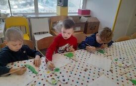 trzech chłopc&oacute;w maluje choinki