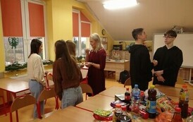 Uczniowie klasy &oacute;smej dzielący się opłatkiem