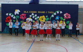 Uczniowie klasy pierwszej tańczą i śpiewają do piosenki dla mamy i taty