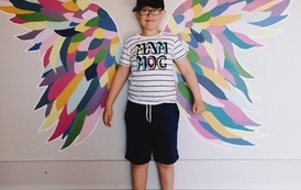 Chłopiec na tle kolorowych skrzydeł